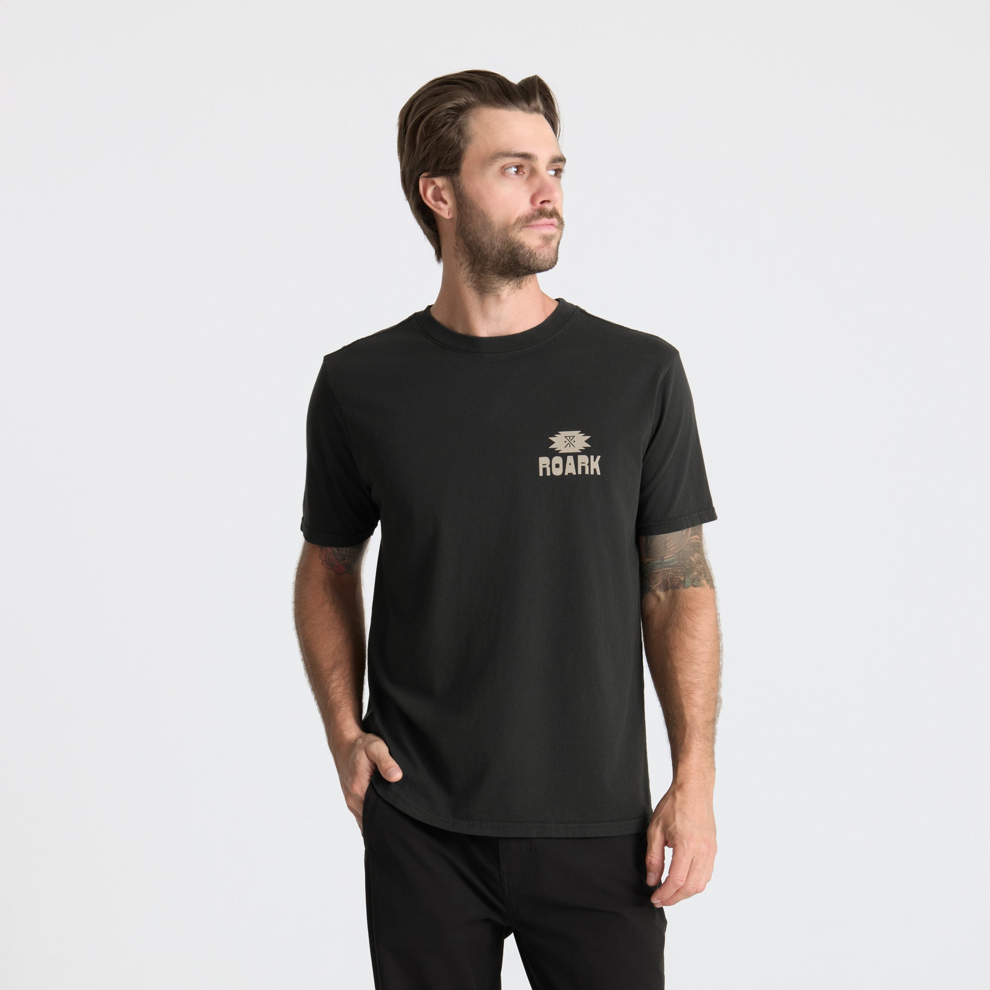 Close up of a black active shirt featuring a stylish white sleeve detail and a practical pocket, ideal for outdoor and adventure activities.